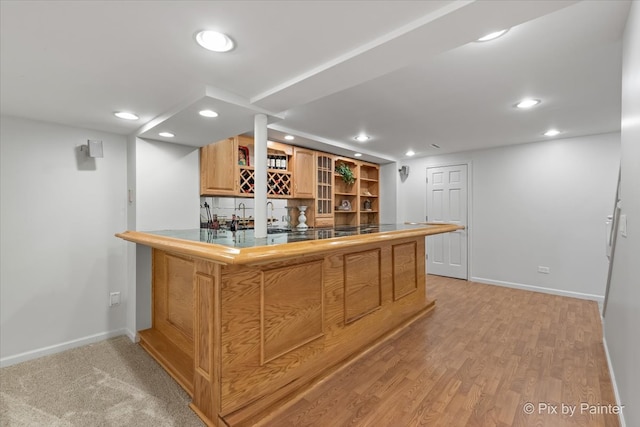 bar with tile counters and light hardwood / wood-style floors