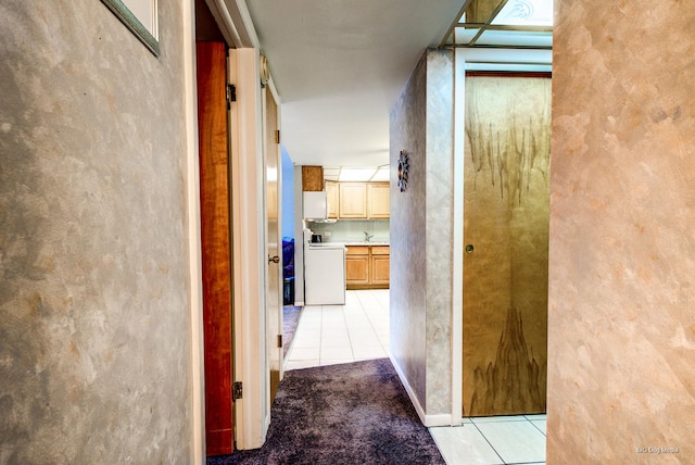 hallway featuring light tile patterned flooring and light carpet