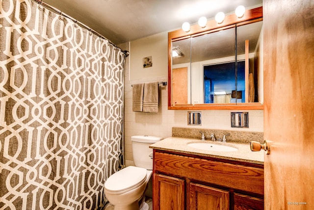 full bathroom with a shower with shower curtain, toilet, vanity, and tile walls
