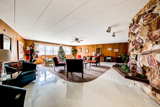 dining space featuring ceiling fan, wooden walls, and a fireplace