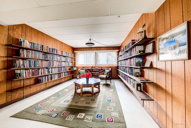 living area featuring wooden walls and bookshelves
