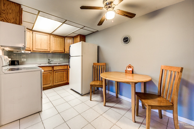 kitchen featuring washer / dryer, white refrigerator, sink, decorative backsplash, and ceiling fan