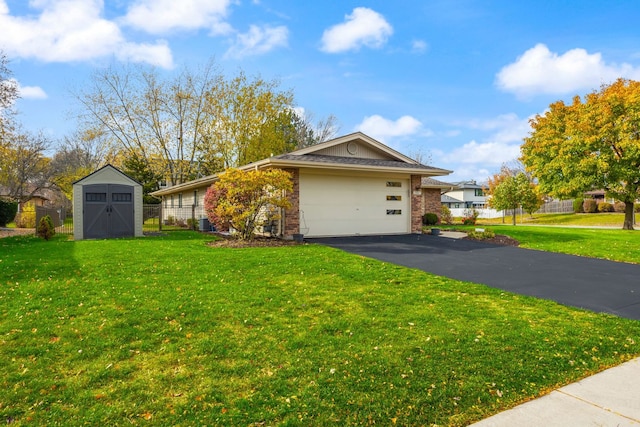 view of front of house featuring a front yard, a garage, and a storage shed