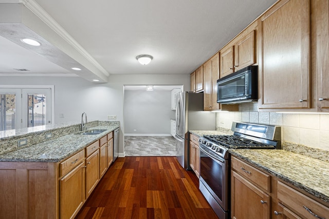 kitchen with dark wood-type flooring, sink, stainless steel appliances, and light stone countertops