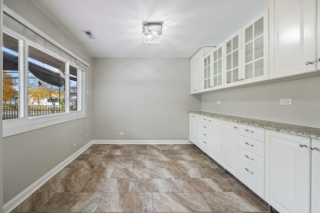 kitchen featuring white cabinetry and light stone counters