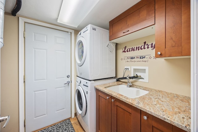 laundry room featuring stacked washing maching and dryer, sink, and cabinets