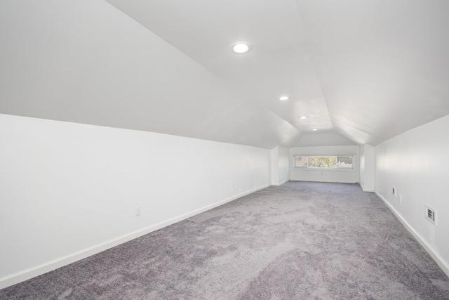 bonus room with carpet flooring and vaulted ceiling