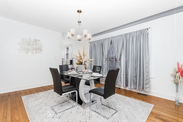 dining area with an inviting chandelier and hardwood / wood-style floors