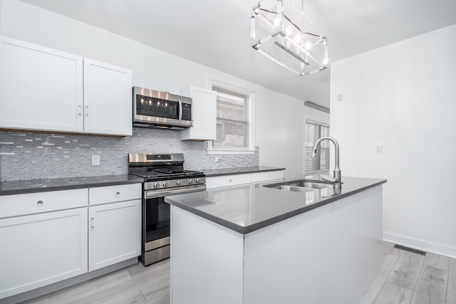 kitchen featuring a notable chandelier, white cabinetry, appliances with stainless steel finishes, and sink