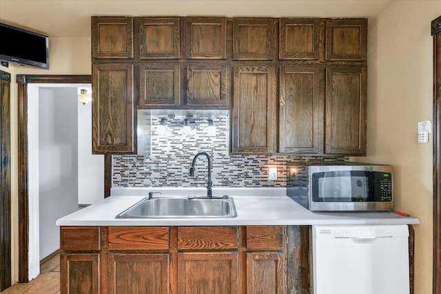 kitchen featuring decorative backsplash, sink, white dishwasher, and light tile patterned floors