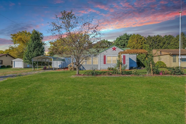 view of front of home with an outdoor structure, a yard, a garage, and a carport