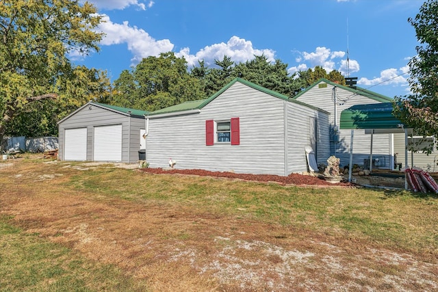 exterior space featuring a yard, an outbuilding, and a garage