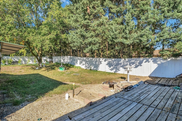 view of yard with a wooden deck and an outdoor fire pit