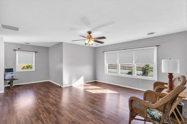 living area with dark hardwood / wood-style floors, ceiling fan, and a wealth of natural light