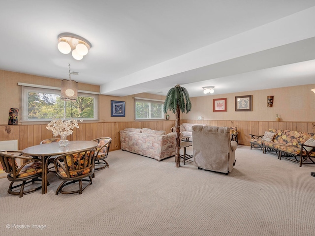 dining room with carpet and wooden walls