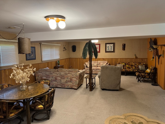 carpeted living room featuring wood walls