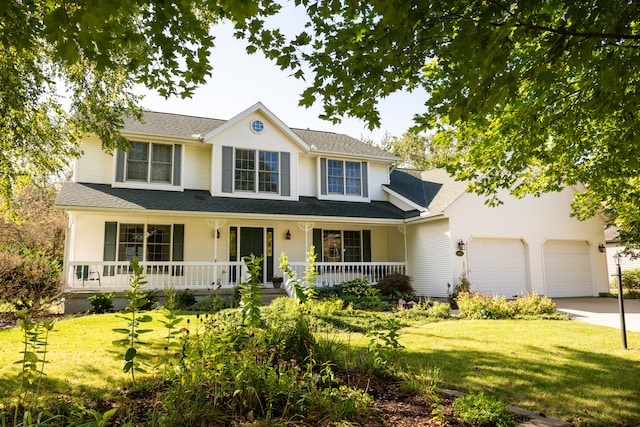 view of front of house with covered porch, a garage, and a front lawn