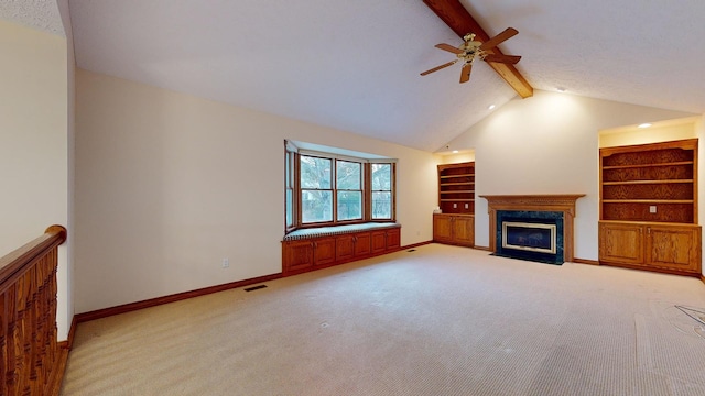 unfurnished living room featuring light carpet, a high end fireplace, lofted ceiling with beams, ceiling fan, and built in features