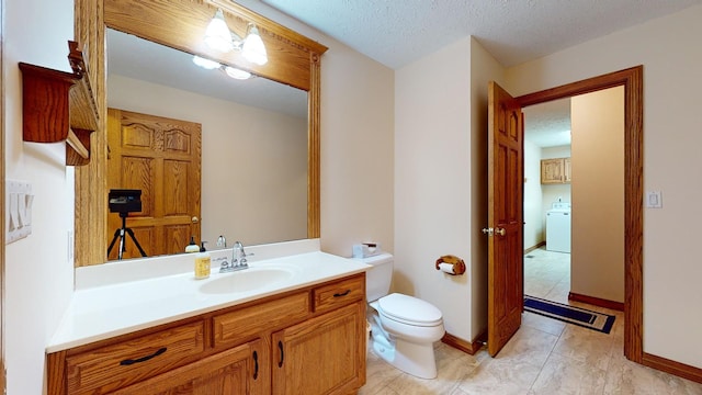 bathroom featuring vanity, a textured ceiling, tile patterned flooring, washer / clothes dryer, and toilet