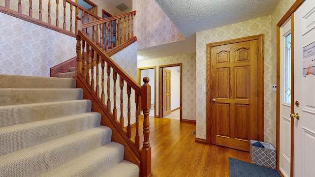 foyer entrance featuring hardwood / wood-style flooring and a textured ceiling