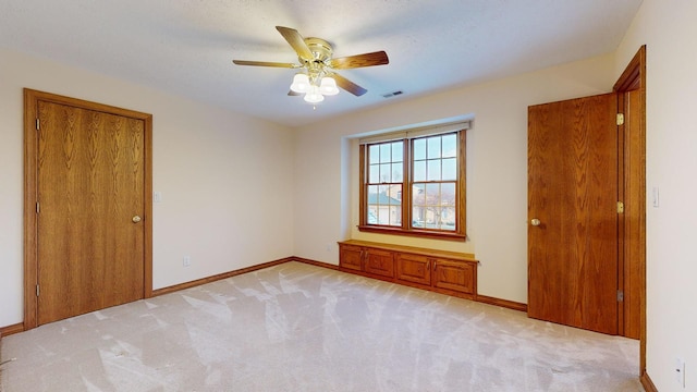 carpeted spare room with ceiling fan