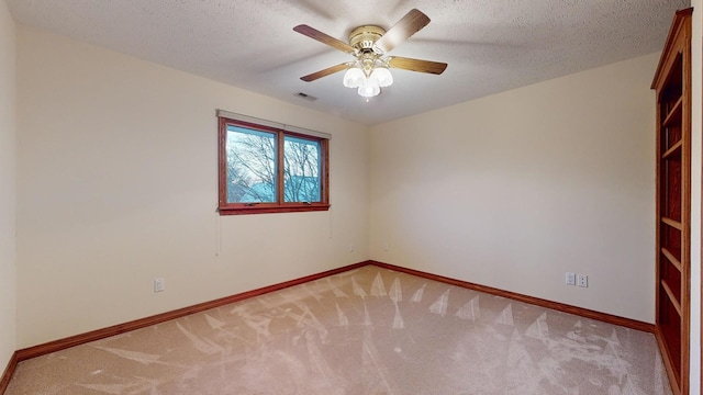 carpeted empty room featuring ceiling fan and a textured ceiling