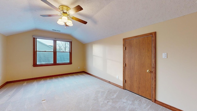 bonus room with ceiling fan, light colored carpet, a textured ceiling, and vaulted ceiling