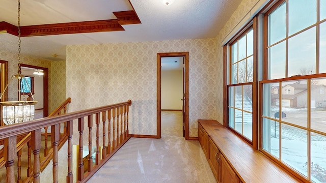 corridor featuring light colored carpet and a textured ceiling