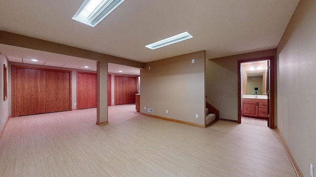 basement featuring sink and light hardwood / wood-style floors