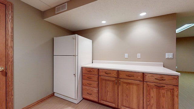 kitchen with light wood-type flooring and white refrigerator