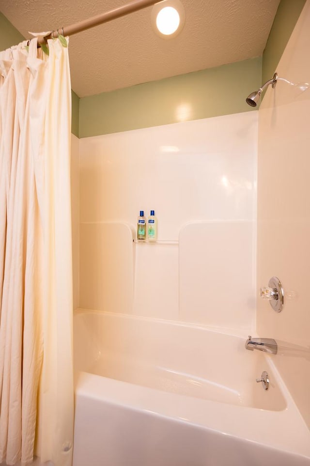 bathroom featuring shower / bath combination with curtain and a textured ceiling