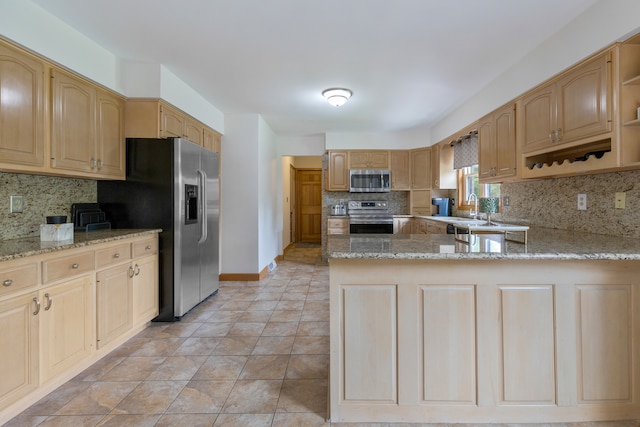 kitchen featuring kitchen peninsula, stainless steel appliances, and tasteful backsplash