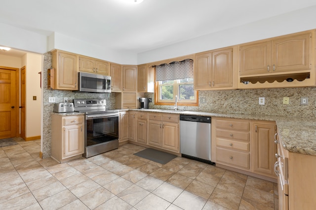 kitchen featuring sink, light tile patterned floors, appliances with stainless steel finishes, light brown cabinetry, and decorative backsplash