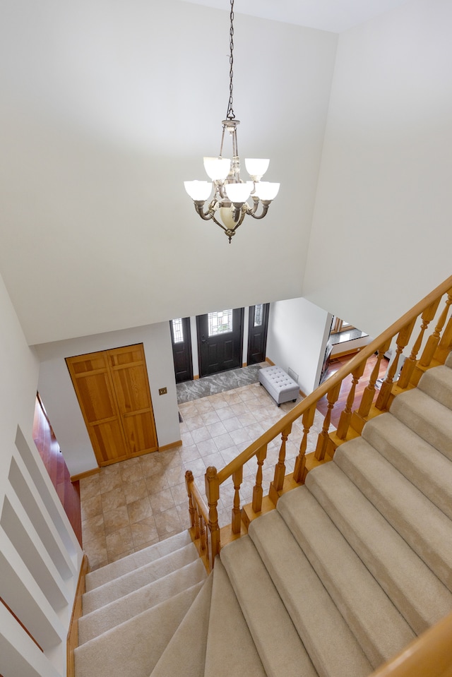 tiled foyer featuring an inviting chandelier and a high ceiling