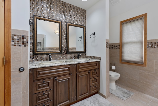 bathroom featuring tile walls, vanity, and toilet