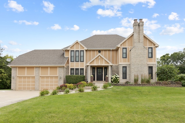 tudor house featuring a front yard and a garage