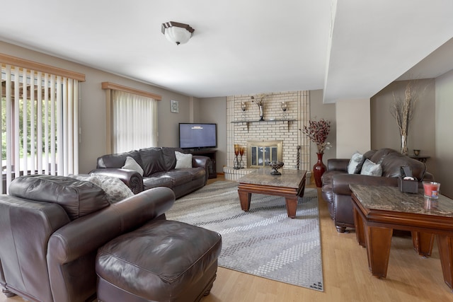 living room featuring light wood-type flooring and a fireplace