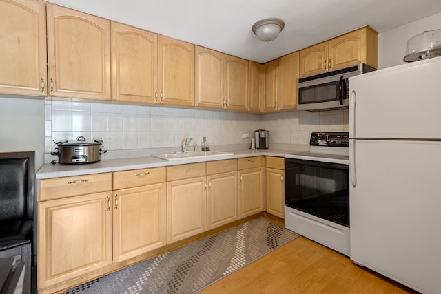 kitchen featuring light hardwood / wood-style floors, light brown cabinetry, white appliances, and sink