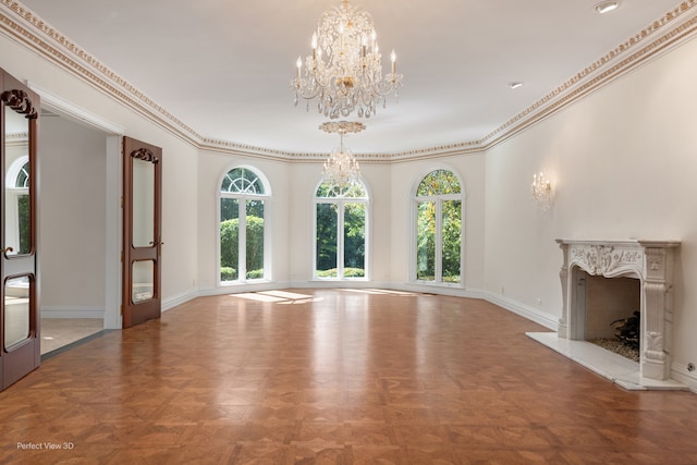 unfurnished living room featuring parquet floors, ornamental molding, a chandelier, and a premium fireplace