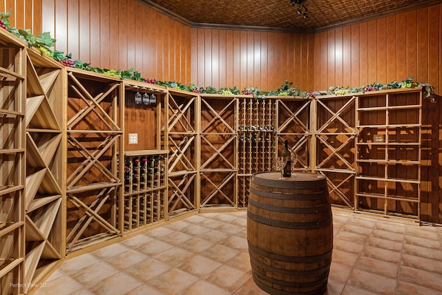 wine area featuring ornamental molding and wooden walls