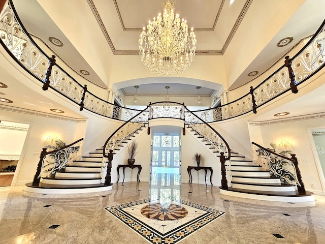 foyer with a notable chandelier, a towering ceiling, and crown molding