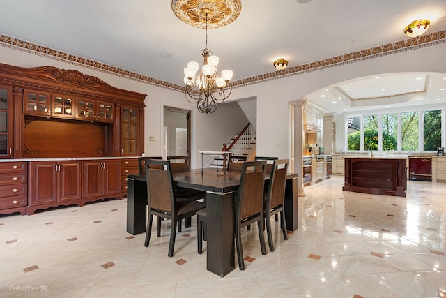 dining area with a raised ceiling, light tile patterned flooring, sink, and a notable chandelier