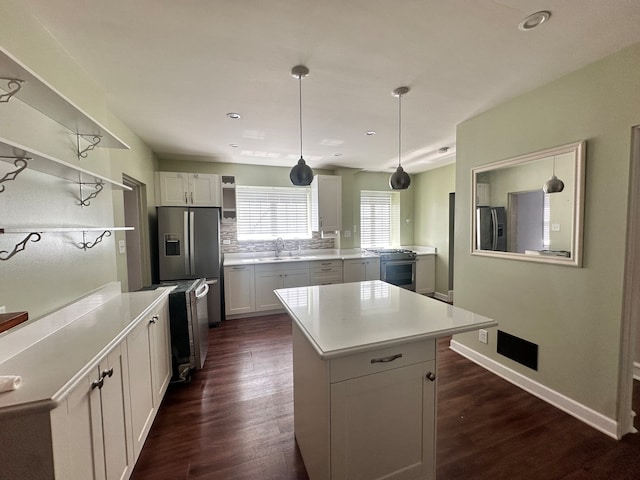 kitchen featuring a center island, dark hardwood / wood-style flooring, stainless steel appliances, and white cabinets