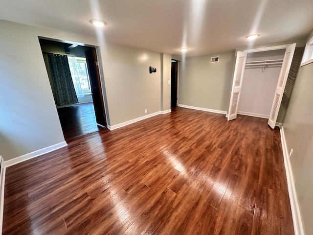 unfurnished bedroom with a closet and dark wood-type flooring