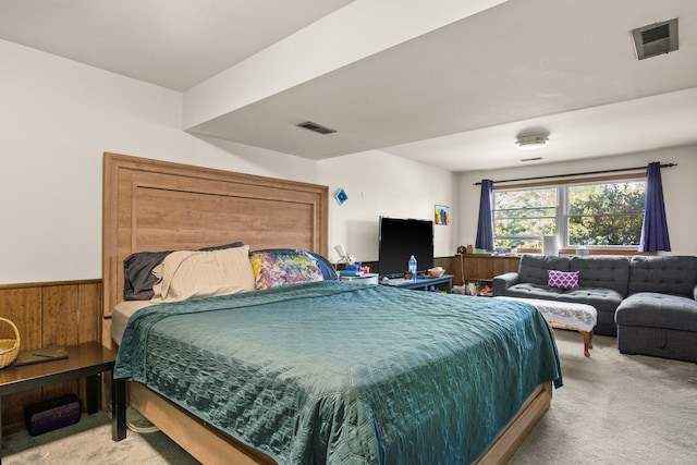 carpeted bedroom with wood walls