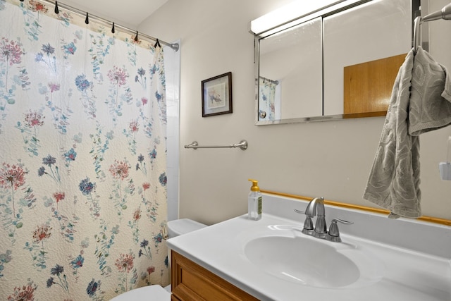 bathroom with curtained shower, vanity, and toilet