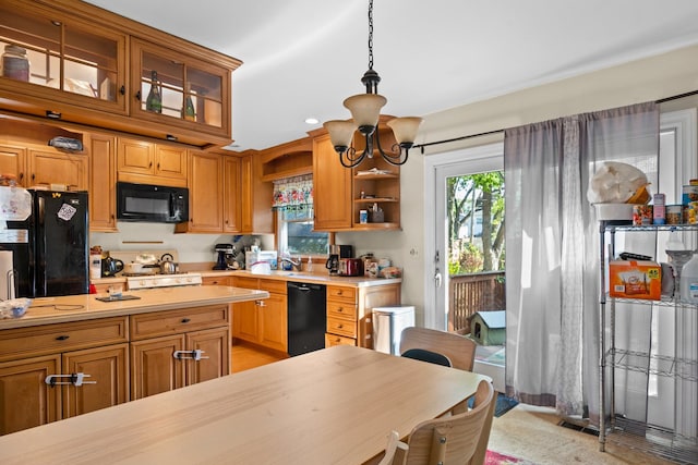 kitchen featuring a notable chandelier, black appliances, sink, and decorative light fixtures