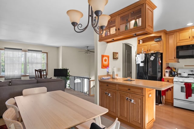 kitchen with black appliances, ceiling fan with notable chandelier, and light hardwood / wood-style flooring