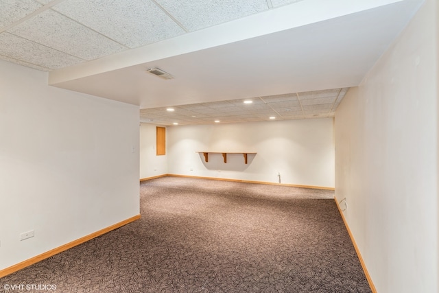 basement featuring a drop ceiling and carpet floors