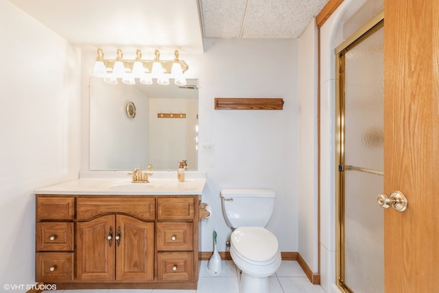 bathroom with vanity, tile patterned flooring, a paneled ceiling, toilet, and a shower with door